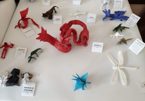 Wystawa prac wykonanych techniką origami przedstawiająca różne bryły i figury zwierząt, postaci z bajek.